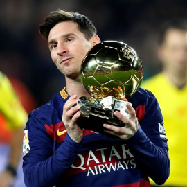 El delantero del Barcelona Lionel Messi ofrece su quinto Balón de Oro a la afición. /EFE