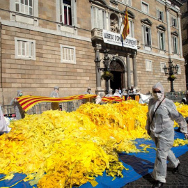 El grupo antiindependentista "Els Segadors del Maresme" volcó el sábado en la plaza de Sant Jaume, frente al Palau de la Generalitat, una decena de sacas con miles de lazos amarillos. /EFE