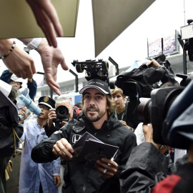 El piloto español de Fórmula Uno Fernando Alonso reparte autógrafos a sus fans en el circuito de Suzuka. /EFE