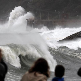 Donostiarras y visitantes observan el fuerte oleaje rompiendo contra el Paseo Nuevo de San Sebastián. EFE/Juan Herrero