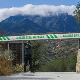 Un agente de la Guardia Civil custodia el acceso a la casa en la que se encontró el cadáver de una mujer con aparentes signos de violencia. EFE