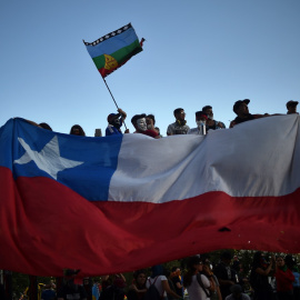 12/11/2019 - Manifestantes sostienen la bandera de Chile y la Mapuche. / AFP - RODRIGO ARANGUA