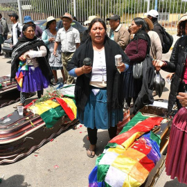 16/11/2019.- Un grupo de mujeres realiza una ceremonia ante los féretros de varios de los fallecidos tras los disturbios de ayer con las fuerzas del orden, frente al Instituto de Investigaciones Forenses este sábado, en Cochabamba (Bolivia)