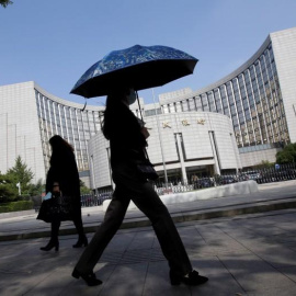 Varias personas pasan por delante de la sede del Banco Popular de China, el banco central, en Pekín. REUTERS/Jason Lee