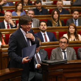 El presidente catalán, Carles Puigdemont, se dirige a la tribuna para su intervención en el debate de la cuestión de confianza, la primera que vive el Parlament desde que fue restablecido y para la que ya cuenta con el aval de la CUP, en la