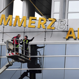 Fotografía de archivo que muestra a unos trabajadores mientras desmontan el logo del banco Commerzbank en Fráncfort. EFE/Daniel Reinhardt