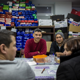 Jonatan Urdaneta y Alexander Orellana, solicitantes de asilo venezolano y salvadoreno, durante su comida de despedida con Mauricio Castaneda y Aida Burgo, procedentes de El Salvador, en el local de la Red Solidaria de Acogida en Puerta del 