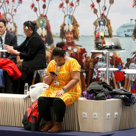 Una mujer observa su móvil en uno de los stands de la 25 Conferencia de las Partes del Convenio Marco de Naciones Unidas sobre Cambio Climático (COP), en Madrid. EFE/Chema Moya