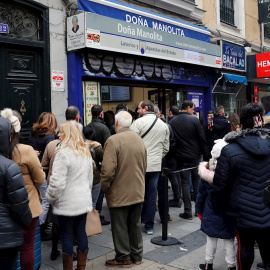 08/12/2019.- Decenas de personas hacen cola  en la administración de Loterías Doña Manolita, en Madrid, para comprar la tradicional lotería de Navidad. / EFE - BALLESTEROS