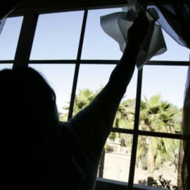 Una mujer limpia unos cristales de una casa. REUTERS/Archivo.