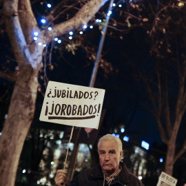 Manifestante con un pancarta en una protesta contra los recortes. AFP