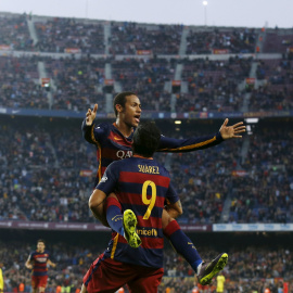 El delantero uruguayo Luis Suarez levanta a su compañero Neymar, tras su segundo gol frente al Villarreal en el Camp Nou. REUTERS/Albert Gea