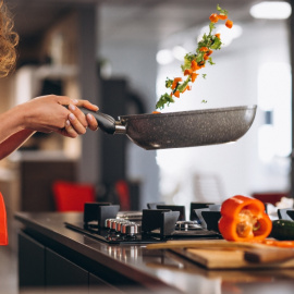 Mujer cocinando en casa. 