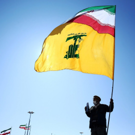 Un irání sostiene una bandera de su país y de Hezbolá durante los actos de celebración del 41 aniversario de la Revolución Islámica, en Teherán. REUTERS