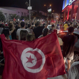 La gente celebra en las calles de Túnez después de que el presidente tunecino Kais Saied anunciara la suspensión del Parlamento y la destitución del primer ministro Hichem Mechichi, tras las protestas contra el partido gobernante. AFP/FETHI