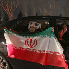  Los iraníes ondean la bandera nacional mientras celebran en la capital, Teherán, el 27 de enero de 2022, después de clasificarse para la final de la Copa del Mundo de 2022 en Qatar.- AFP