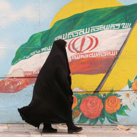 Una mujer camina junto a un mural que muestra la bandera de Irán, en Teherán, a 6 de diciembre de 2022. -Majid Asgaripour / WANA (West Asia News Agency) via REUTERS