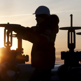 Un trabajador maneja la válvula de un conducto de petróelo en un campo petrolífero de la compañía rusa Lukoil en Sberia. REUTERS/Sergei Karpukhin