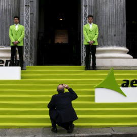 Un hombre toma una foto en la entrada del edificio de la Bolsa de Madrid el día del estreno en el mercado de AENA, en febrero de 2015.  REUTERS/Susana Vera