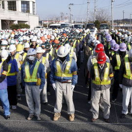 Trabajadores de la descontaminacion de la zona de  Fukushima guardan un minuto de silencio en la ceremonia en recuerdo de las víctmas del tsunami de marzo de 2011. REUTERS/Kyodo