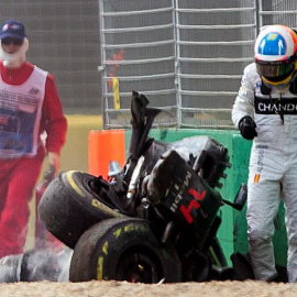 Alonso camina al lado de su monoplaza destrozado tras el accidente en Melbourne. /EFE