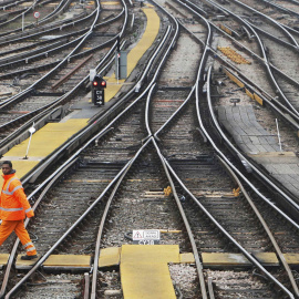 Un trabajador atraviesa las vías de la estación ferroviaria de Clapham Junction, en Londres. REUTERS/Luke MacGregor