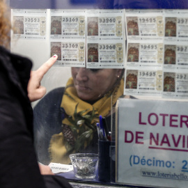 Una mujer escoge un décimo en una administración de Lotería en Valencia. EFE/Manuel Bruque