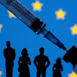 A vial, sryinge and small toy figures are seen in front of a displayed EU flag in this illustration taken January 11, 2021. REUTERS/Dado Ruvic/Illustration