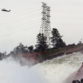 Un helicóptero sobrevuela la presa Oroville y el río Feather con sacos cargados de rocas para aliviar la emergencia ocasionada por la erosión del desagüe en la represa Oroville hoy, lunes 13 de febrero de 2017, en Oroville, California (EE.U