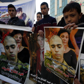 Palestinos sostienen pancartas con la imagen del soldado israelí Elor Azaría, durante una protesta en la ciudad cisjordana de Hebrón. EFE/ABED AL HASLHAMOUN