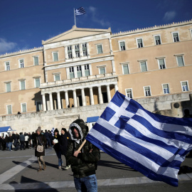 Un agricultor, con la bandera nacional griega, en la ateniense Plaza de Syntagma, donde está el Parlamento, tras una manifestación reclamando la bajada de impuestos.. REUTERS/Alkis Konstantinidis