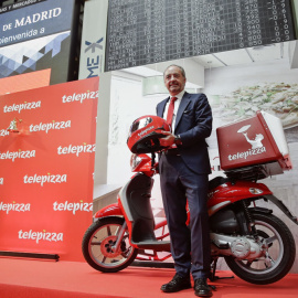 El presidente de Telepizza, Pablo Juantegui, compañía que se ha estrenado en la Bolsa de Madrid, posa en el parqué madrileño junto a una de las típicas motos de reparto. EFE/Emilio Naranjo