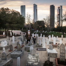 Una madre y su hijo observan el cementerio que Save the Children ha simulado en un parque de Madrid para recordar que, en Siria, han muerto 16.000 niños desde que comenzó la guerra, hace seis años. PEDRO ARMESTRE / SAVE THE CHILDREN