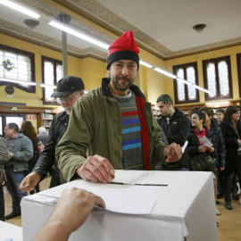 Un ciudadano, con barretina, deposita su papeleta durante la jornada de votación del 9-N. EFE/Archivo