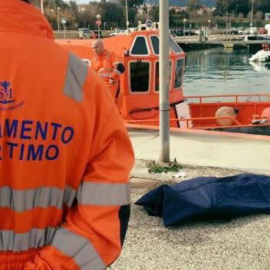 Un miembro de Salvamento Marítico junto al cuerpo rescatado de un inmigrante fallecido.- SALVAMENTO MARÍTIMO