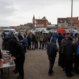 Varios refugiados esperan en la cola para recibir comida / ENRIC BONET