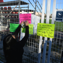  Una mujer coloca carteles para mostrar rechazo al nuevo entrenador del Rayo Vallecano, durante un partido de fútbol.- Fernando Sánchez / Europa Press