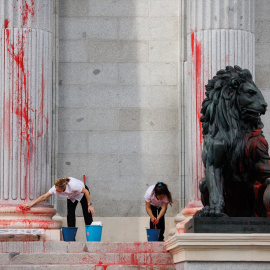  Dos operarias limpian el león del Congreso tras ser pintado por una protesta de Futuro Vegetal, a 30 de marzo de 2023. Alejandro Martínez Vélez / Europa Press