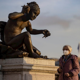 Una mujer con mascarilla protectora camina por el Puente Alexandre III este jueves en París.