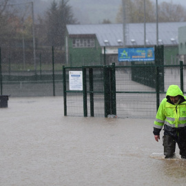 Un operario del Ayuntamiento de Arriondas (Asturias) trata de caminar por una calle completamente inundada este miércoles.