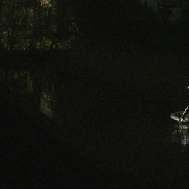 Una luz en mitad de la noche, un hombre que faena solo en la orilla