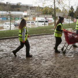 Varios vecinos recogiendo escombros y limpiando desperfectos tras la crecida del río Arga el pasado 11 de diciembre de 2021, en Burlada, Navarra.