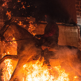 Un caballo salta sobre el fuego en San Bartolome de Pinares en Ávila en "Luminarias" en honour a San Antonio Abad.- GABRIEL BOUYS / AFP)