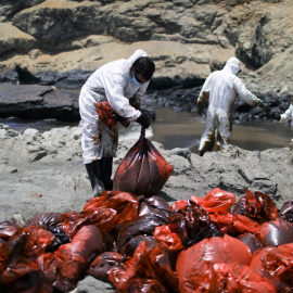 Voluntarios y pescadores recogen petróleo de la costa de Ventanilla.