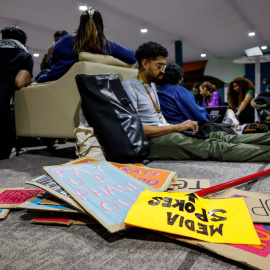 Varias personas trabajan junto a una pila de pancartas en las inmediaciones de la COP29, a 22 de noviembre de 2024.