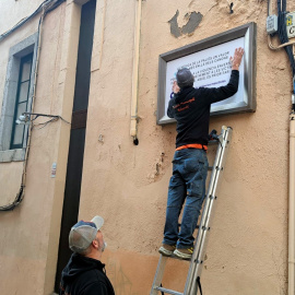 Els operaris tapant la placa dedicada a Ortega Monasterio per l'altra a favor dels drets de les dones arran del 25-N