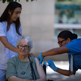 Personal sanitario vacuna a una mujer. Imagen de archivo.