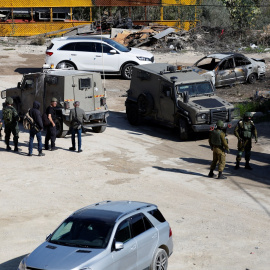 Un grupo de soldados israelís permanecen apostados cerca de un coche dañado, después de un ataque de su Ejército en Hawara, cerca de Nablus, en la Cisjordania ocupada. REUTERS/Mohammed Torokman