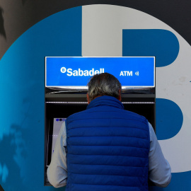 Un hombre opera un cajero automátivo del Banco Sabadell en una de sus oficinas en Madrid. REUTERS/Susana Vera