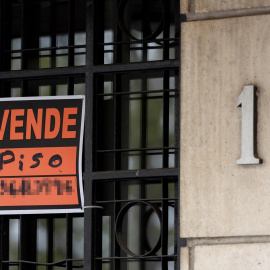 Vista de un cartel de 'Se vende' en un portal de un edificio.